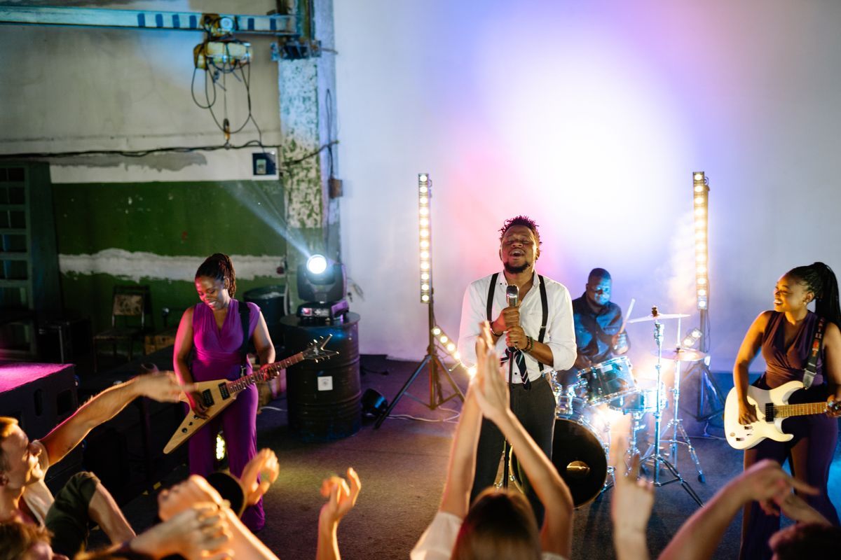 A band mid-set with the crowd's hands up