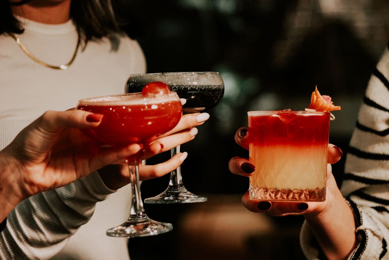Friends raising cocktails in a toast at a local bar