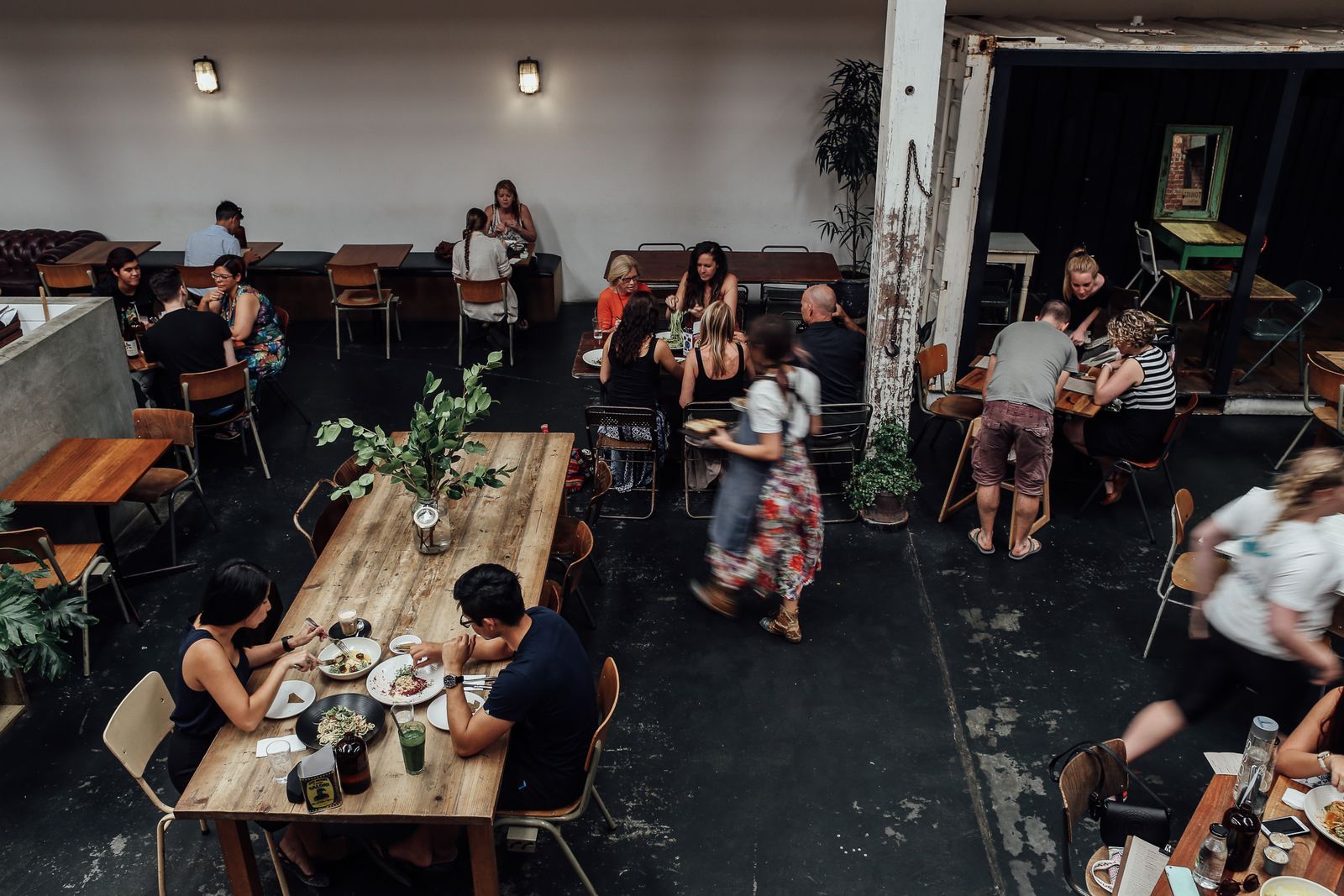 A busy independent restaurant, guests at every table, servers moving through the room