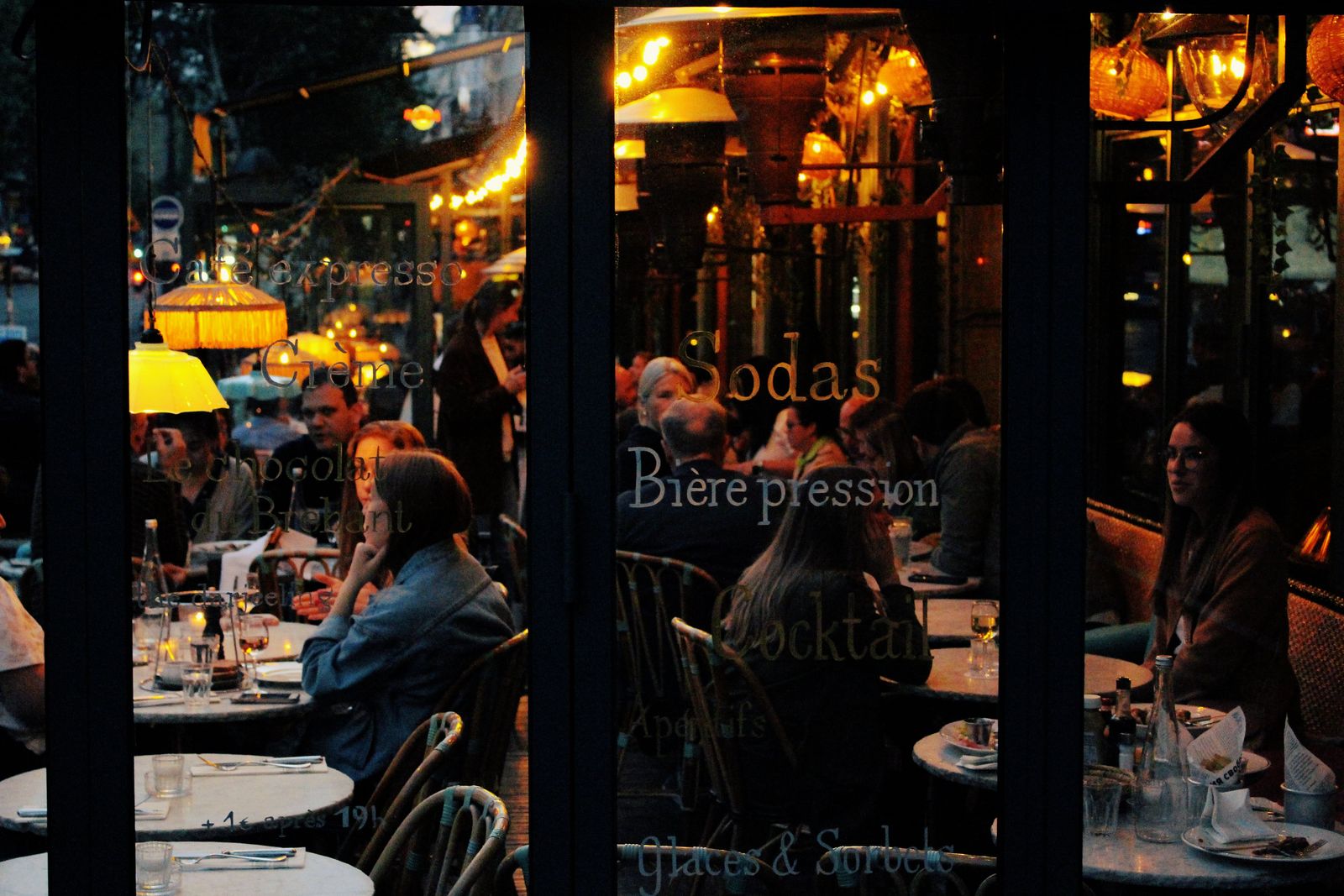 A packed Hampton Roads restaurant at night, seen through the front windows