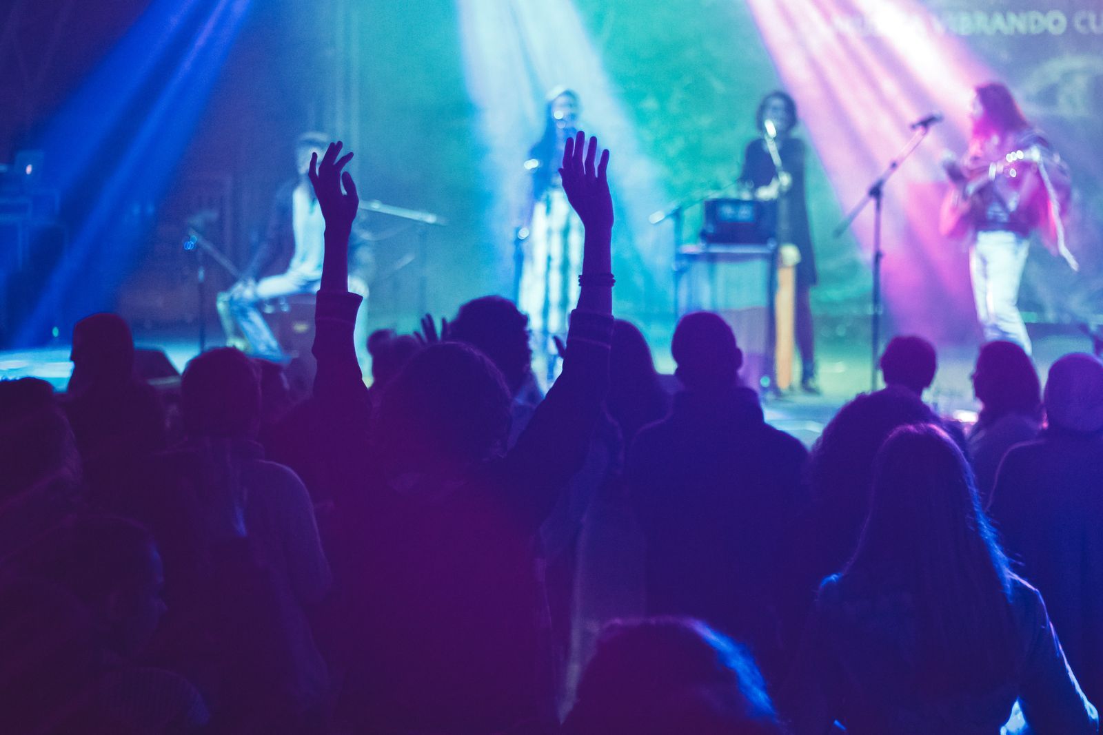 A crowd watching a band under stage lights